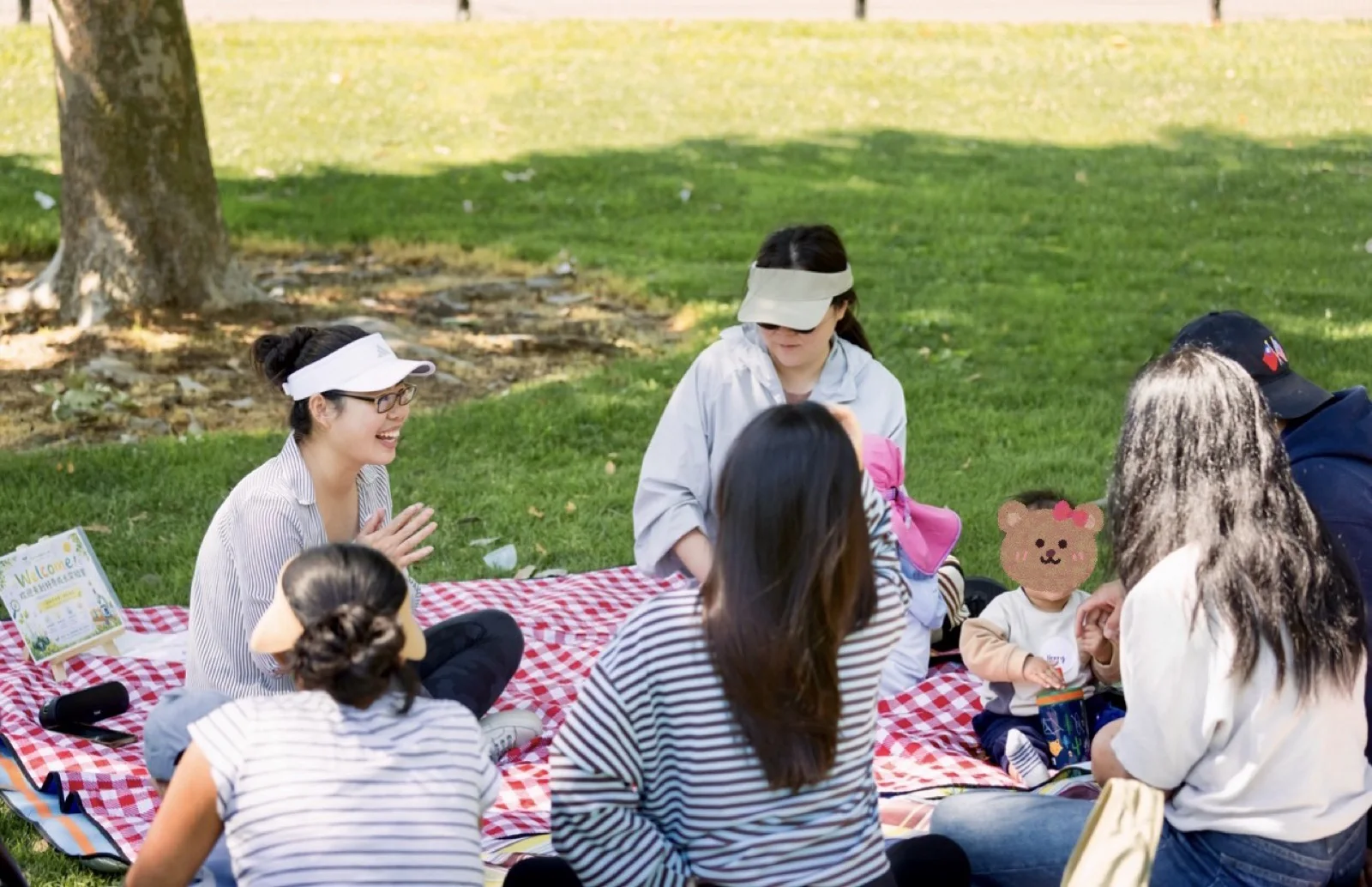 Ning leading a Mandarin Little Circle gathering with children and caregivers in a park